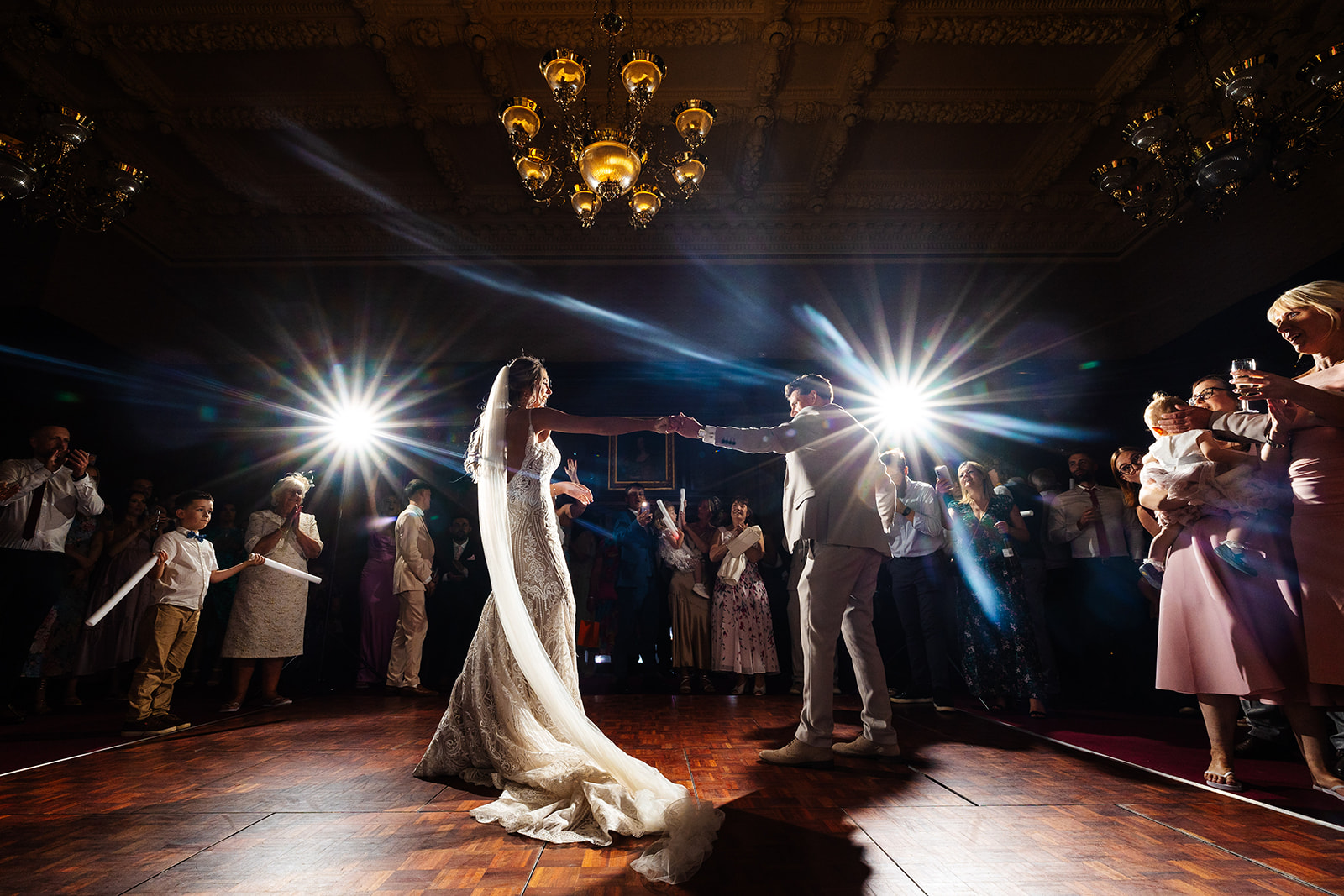 Couple share first dance, spotlights are in the background 