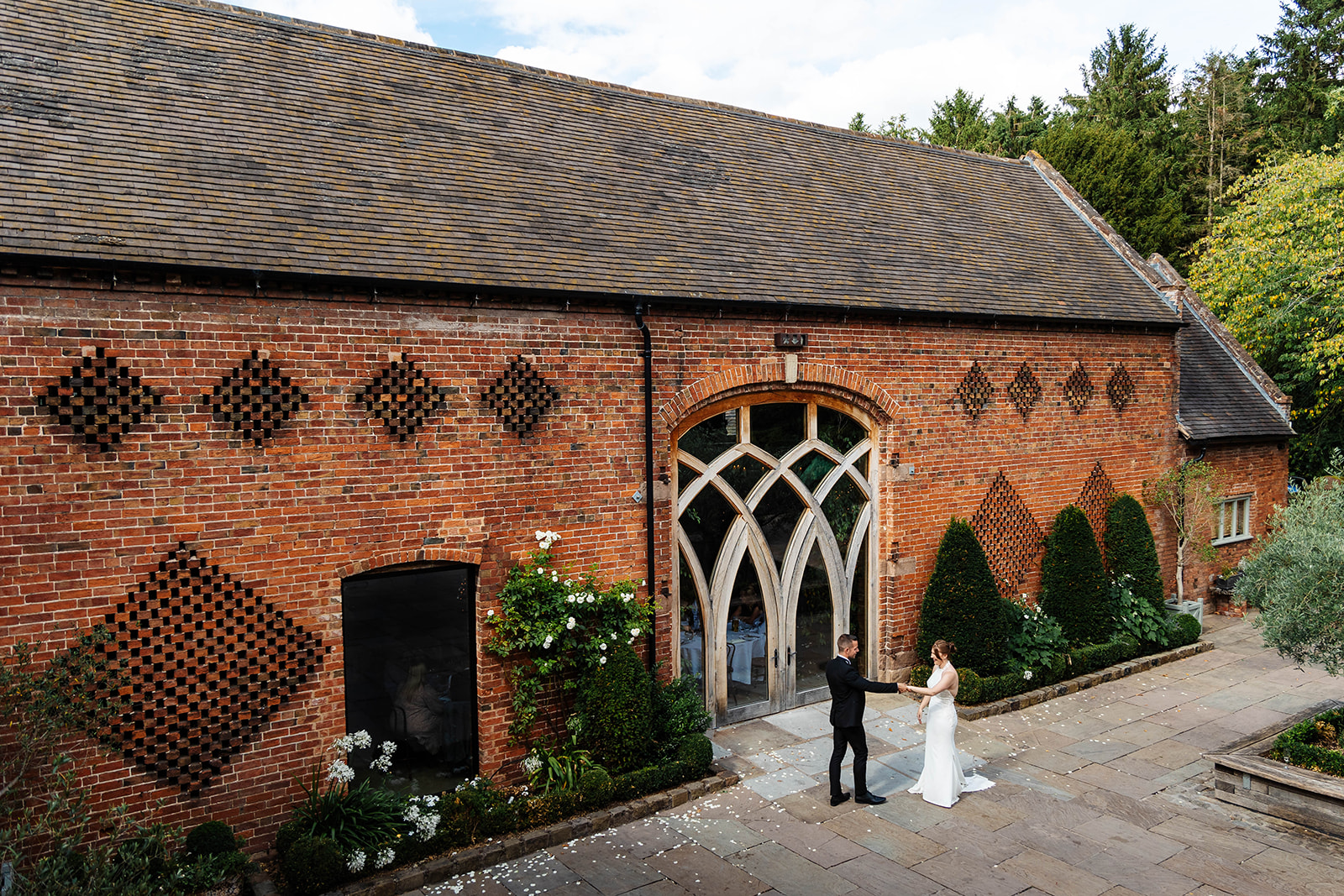 bride and groom dancing in front of brick cripps venue shustoke barn